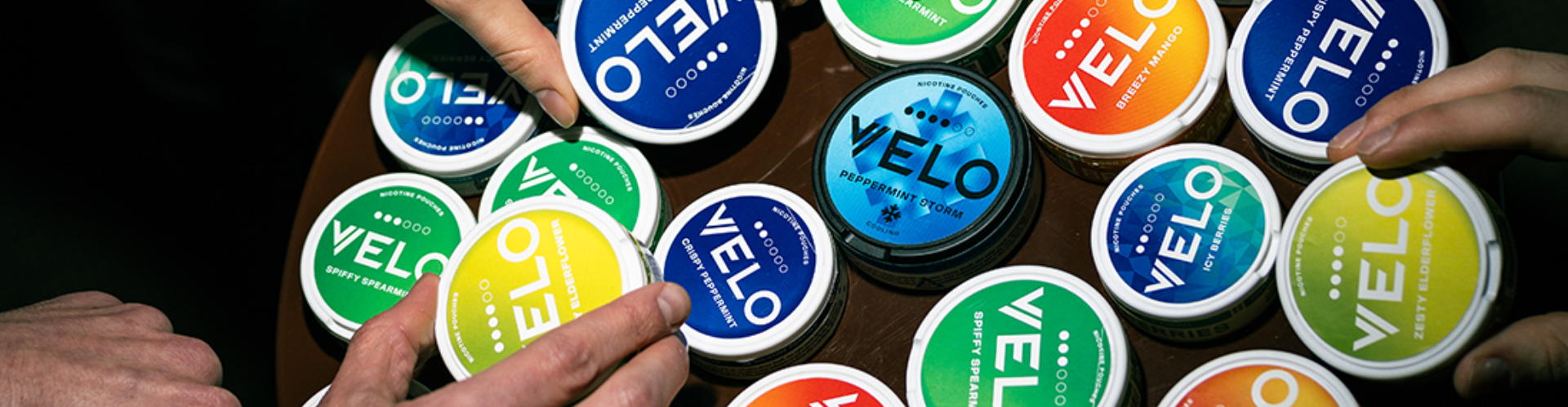 Two people enjoying the winter ski slopes in the snow with VELO nicotine sachets.