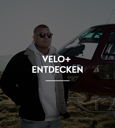 Ein Velo-Influencer an einem Strand mit einem Hubschrauber.