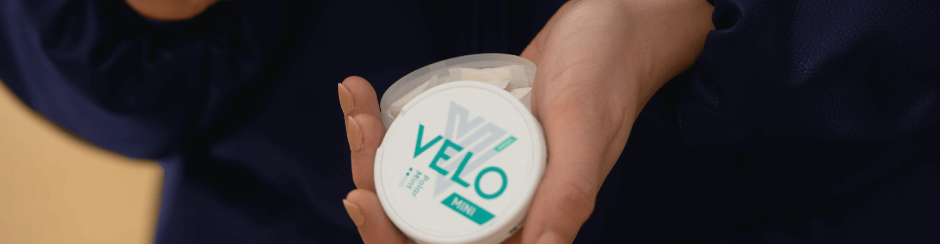 Une boîte de sachets de nicotine VELO ouverte posée dans la main d'un utilisateur